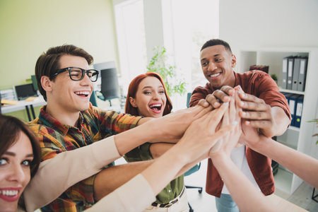 Photo of nice young people give high five celebrate success comfortable modern office loft room interior indoors workspaceの写真素材