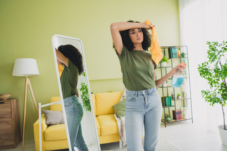 Photo of nice young girl tired cleaning house mirror wear green clothes modern daylight cozy...