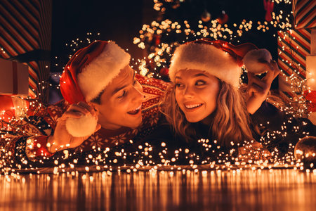 Full length photo of young couple lying floor look each other dressed christmas garment tradition atmosphere decor house indoors roomの写真素材