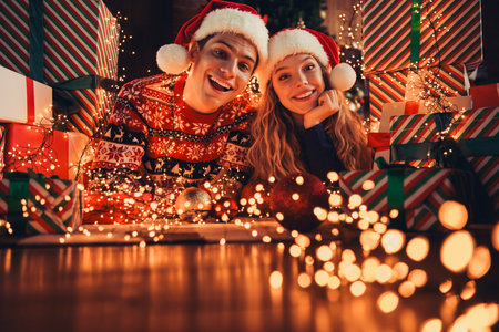 Full body photo of nice young couple lying floor pile gifts wear christmas clothes enjoy cozy x-mas party decoration interior flat indoorsの写真素材
