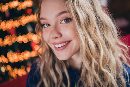 Photo of nice blonde teen girl look camera cheerful smile wear christmas clothes enjoy cozy x-mas party decoration interior flat indoorsの写真素材