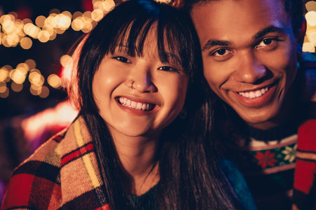 Photo of happy young couple cover blanket cheerful smile dressed christmas garment tradition atmosphere decor house indoors roomの写真素材