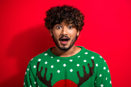 Portrait of nice young man open mouth wear new year xmas sweater isolated on red color backgroundの写真素材