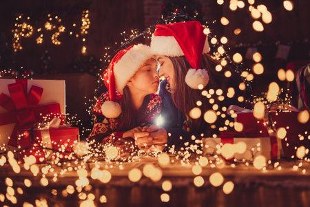 Portrait of two people mother daughter closed eyes festive christmas time decor illumination flat indoorsの写真素材