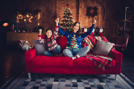 Full size photo of small daughter mother sit sofa winning wear christmas clothes enjoy cozy x-mas party decoration interior flat indoorsの写真素材