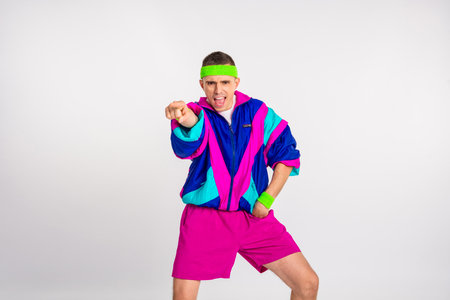 Energetic young man in vibrant 80s sportswear striking a dynamic pose against a white background.