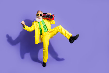Photo of extravagant positive cool pensioner wear yellow stylish outfit celebrate event isolated on...