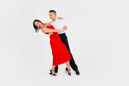 Full body portrait of two young elegant people dancing concert empty space isolated on white color backgroundの写真素材