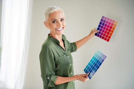 Photo of charming attractive woman dressed khaki shirt rising colors palettes indoors house apartment roomの写真素材