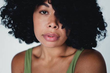 Portrait of a confident young woman with natural beauty and curly hair in a studio settingの写真素材