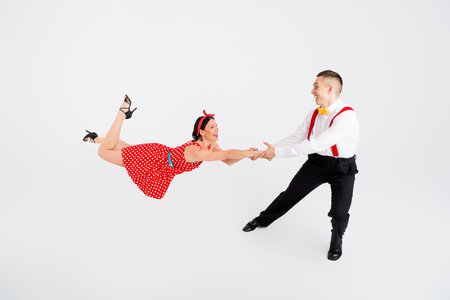 Photo of attractive active couple professional choreographers dancing dynamic rumba isolated on white color backgroundの写真素材