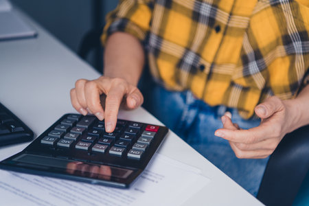 Cropped photo of senior female use calculator accountant wear plaid yellow shirt coworking successful nice light officeの写真素材