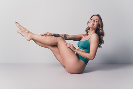 Full length no filter studio photo of slender excited woman underwear enjoying self acceptance isolated white color backgroundの写真素材