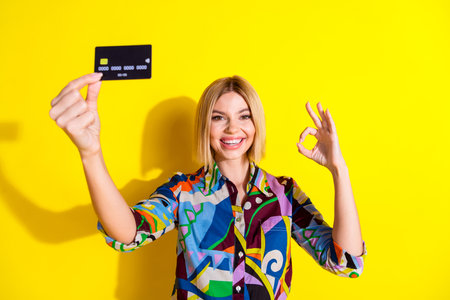 Photo portrait of lovely young lady hold credit card show okey dressed stylish colorful garment...