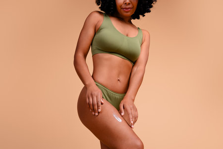 Cropped photo of attractive lady look touch legs applying pampering cream for anti cellulite isolated pastel color backgroundの写真素材