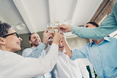 Photo low view of coworking project teamwork people toast drink champagne work together conference meeting successful nice light officeの写真素材