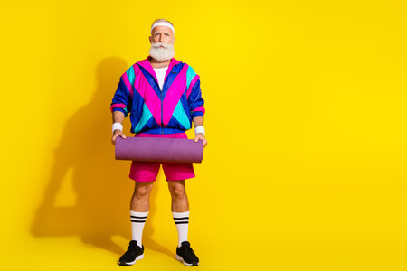Full body photo banner of funny senior sportsman hold mat warmup dressed stylish retro sport costume isolated on yellow color backgroundの写真素材