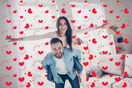 I want to fly higher Concept of happiness tenderness romantic. Cheerful glad excited cute extremely happy attractive woman is showing a plane riding on her delightful boyfriends back in a new houseの写真素材