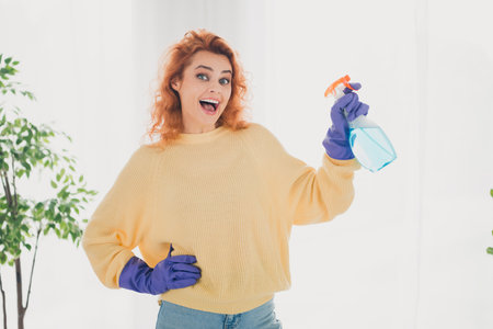 Photo of shiny cute girl dressed yellow jumper enjoying washing rising pulverizer indoors house apartment roomの写真素材