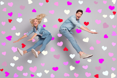 Full length body size view of attractive friends friendship jumping having fun fooling isolated over grey pastel color backgroundの写真素材