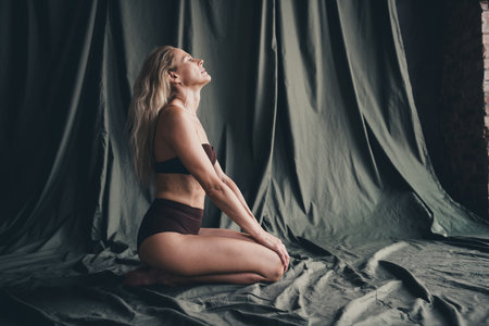 Full length no filter studio photo of dreamy pretty woman wear lingerie loving herself isolated khaki textile backgroundの写真素材