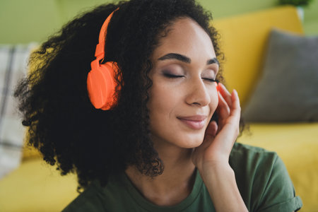 Portrait of nice young girl closed eyes arm touch headphones pastime weekend living room flat...