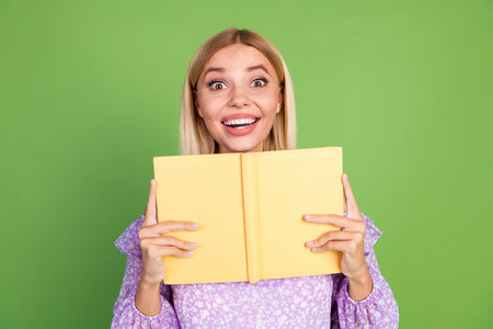 Photo of funny cute girl wear trendy purple clothes hold book isolated on green color background
