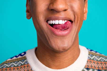 Cropped portrait of nice young man tongue lick teeth wear pullover isolated on turquoise color backgroundの写真素材