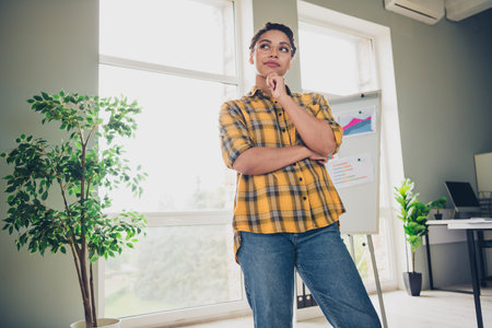 Photo of attractive young woman look minded empty space wear yellow plaid shirt comfortable modern...