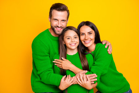 Photo of family with people together hugging daughter in harmony smiling toothily cheerfully...