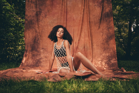 Photo session outdoors of lovely lady wearing stylish lace tunic isolated on textile backdropの写真素材