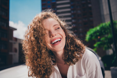 Photo of cheerful cute adorable girl laugh good mood wear white shirt enjoying free time sunny weather outdoors modern cityの写真素材