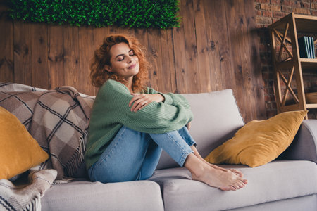 Photo of shiny cute woman dressed green cardigan smiling relaxing indoors house apartment roomの写真素材