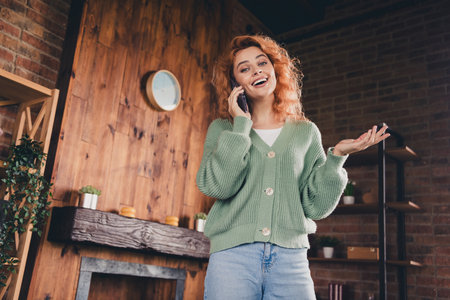 Photo of positive good mood woman dressed green cardigan talking modern gadget indoors house apartment roomの写真素材