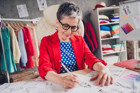 Photo of aged clothing designer lady sit chair draw concept loft interior office studio indoorsの写真素材