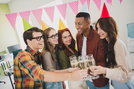 Photo of young age specialists together enjoying spending time with each other drink champagne at...