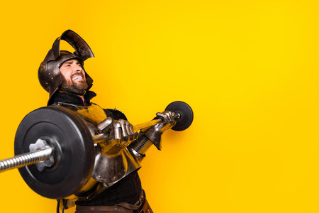 Medieval Knight Lifting Weights Against a Bright Yellow Backgroundの写真素材