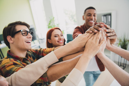 Photo of lovely young people highfive celebrate success startup teambuilding comfortable startup office loft room interiorの写真素材
