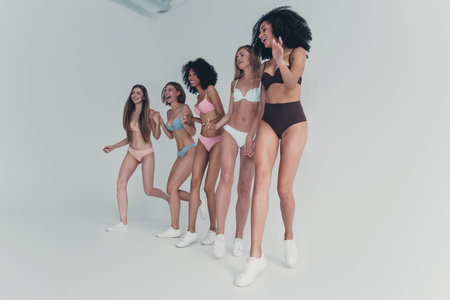 Group of young women in natural unretouched lingerie photoshoot showcasing diversity and beautyの写真素材