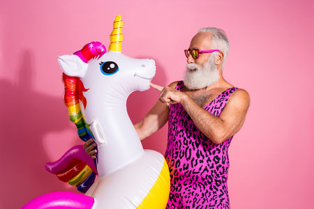 Photo of funny man wear swimwear enjoy relax rest vacation resort inflatable toy isolated on pink color backgroundの写真素材