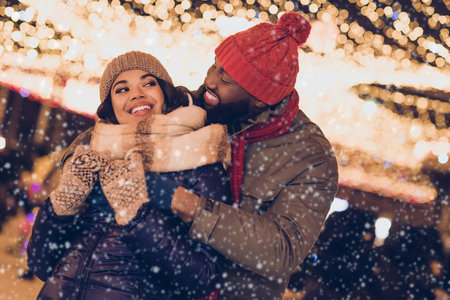 Photo of pretty dreamy boyfriend girlfriend dressed winter season outfits cuddling enjoying noel x-mas outdoors urban city streetの写真素材