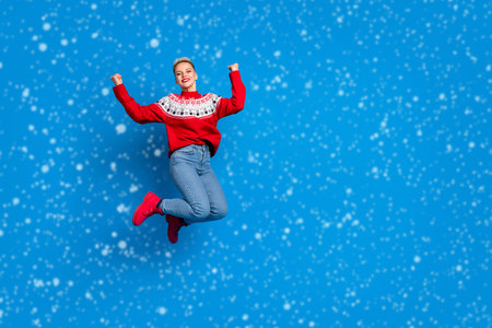 Full body photo of nice overjoyed lady fists up wear red ugly sweater hooray final black friday sale xmas winter season isolated on blue color backgroundの写真素材