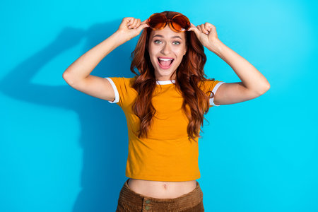 Photo of lovely cheerful cute woman wear trendy clothes isolated on blue color backgroundの写真素材