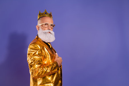 Profile photo of charismatic extravagant aged man empty space ad wear golden costume isolated on violet color backgroundの写真素材