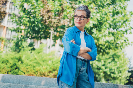 Photo of nice aged lady folded arms think wear blue shirt downtown street city outdoorsの写真素材