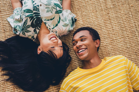 Top view photo of positive cheerful couple wear t-shirts lying floor together good mood romantic date indoors flatの写真素材