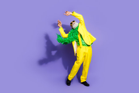 Full size photo of elegant charismatic aged chilling dancing man yellow suit isolated on violet...