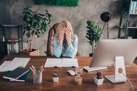 Portrait of young business woman sit chair cry desktop wear shirt loft interior business center office indoorsの写真素材