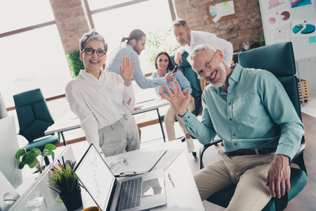 Photo of teamwork people working together wave hand hello greeting comfortable modern office loft...