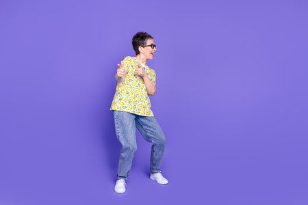 Elderly Woman in Casual Fashion Stance on Purple Background Expressing Cheerfulness and Style
